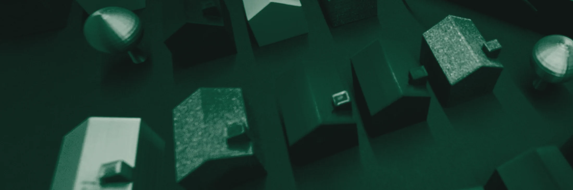 Superfície de mesa com maquetes, documentos e material de trabalho sob luz dirigida